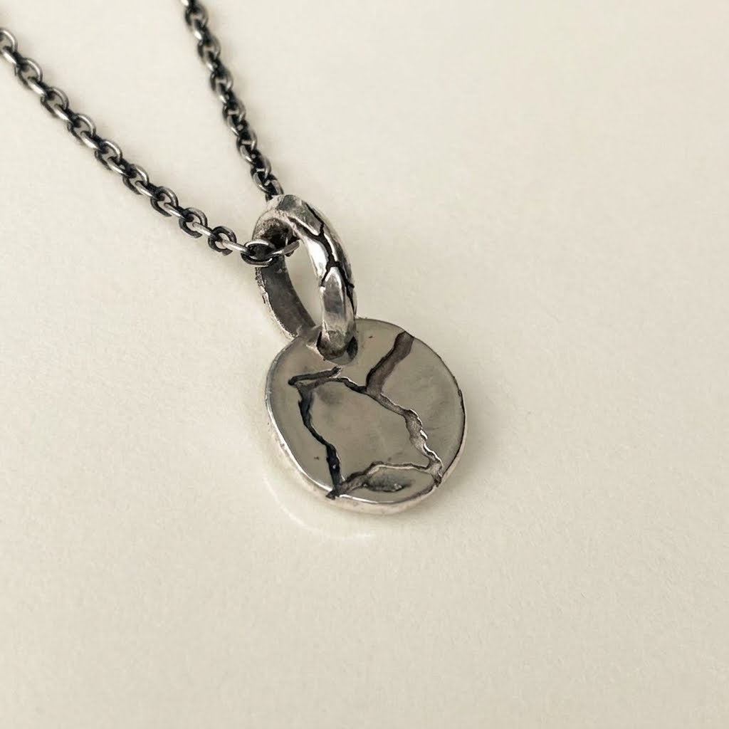 silver pendant round with rough texture