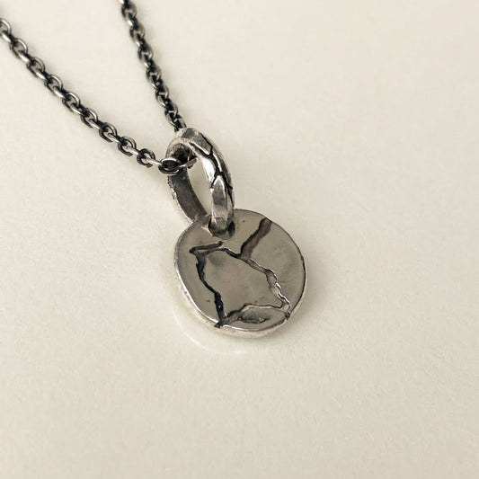 silver pendant round with rough texture